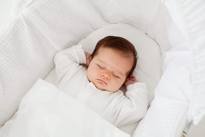 sleeping baby in Moses basket