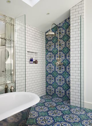 blue Moroccan style tiles in walk in shower, bath tub and mirrored wall