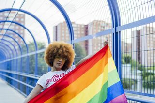proud woman with her gay pride flag on a bridge