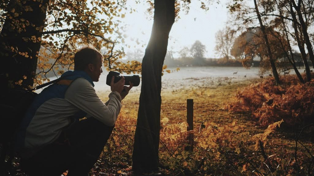 Photographer taking pictures with a camera in a cloudy forest