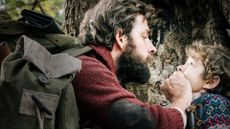 John Krasinski puts his hand over Cade Woodward's mouth while in the woods