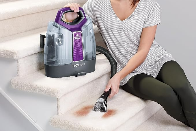 Woman using bissell spotcleaner on carpet