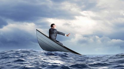 Man on sinking boat in water