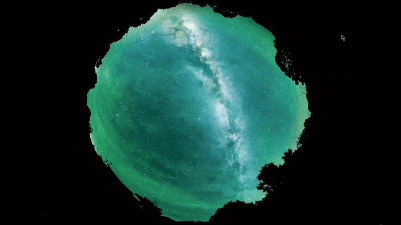 ripples move through a green hazy glow in the night sky with the bright milky way behind.