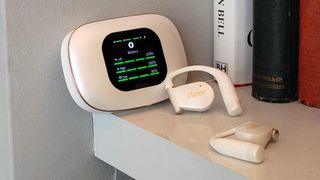 The Cleer Arc 5 buds in a shelf, next to the case.