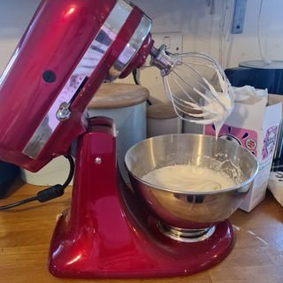 KitchenAid Artisan stand mixer with the whisk attachment whisking some cream