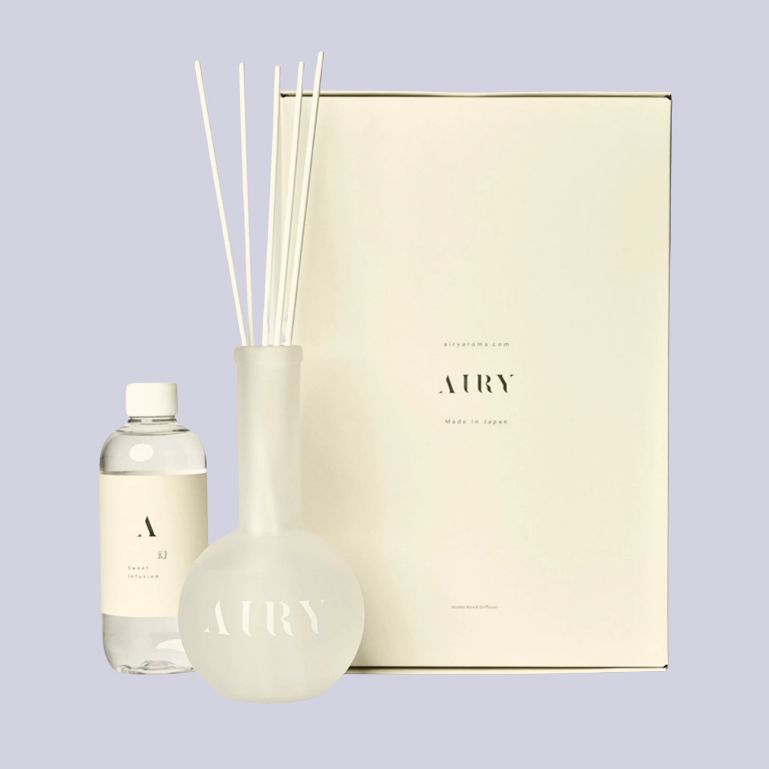 A bottle of reed diffuser liquid by a frosted glass diffuser and a box