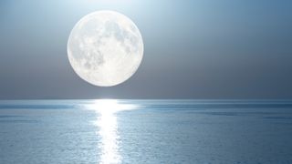 Full moon with a lunar path reflected in the mirror of the sea.