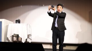 Canon executive Manabu Kato holds the Canon EOS R5 Mark II at the official product announcement