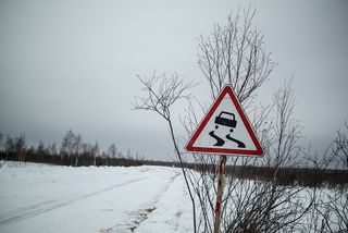 A road sign 'Slippery Road' is seen on a winter road at a market near the Siberia village of Yangutum, on February 2, 2016 in Siberia, Russia.