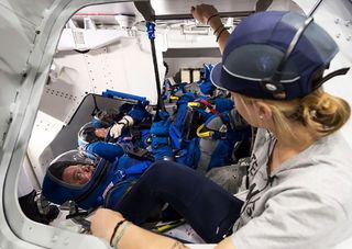 NASA astronauts Bob Behnken, Eric Boe and Doug Hurley perform a fully-suited test in Boeing’s CST-100 Starliner mockup trainer during early May 2018 at the agency's Johnson Space Center in Houston. The astronauts are wearing Boeing's blue spacesuits for Starliner flights.