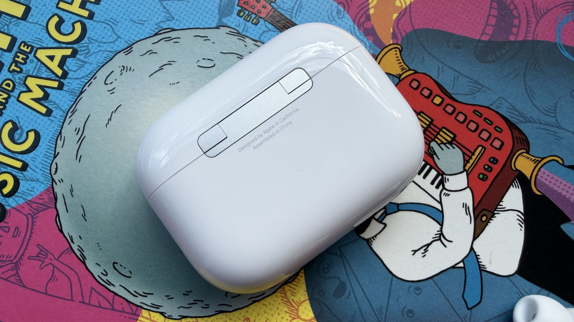 The AirPods Pro 3 earbuds from Apple against the pages of a graphic novel.