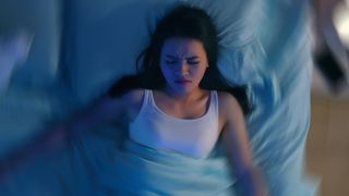 A person asleep in bed, suffering from sleep paralysis
