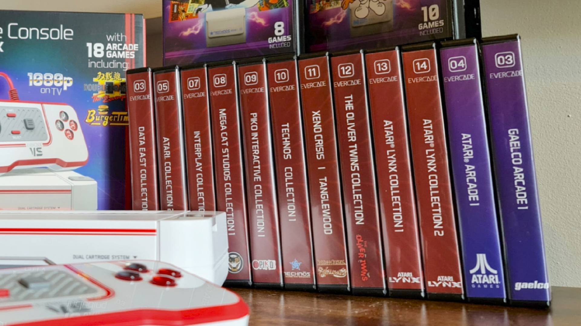 Evercade game boxes lined up in a row with Evercade VS console on left hand side.