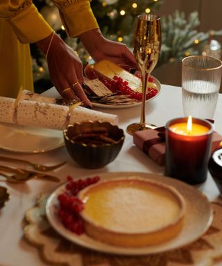 festive dining table with crackers and gold Champagne flutes and cheesecake