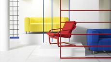A white room with industrial frames in primary colors and a red POANG recliner chair