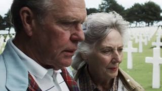 An older man and an older woman standing in a cemetery in Saving Private Ryan