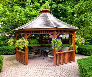 A gazebo in landscaped garden with an interlocking stone patio