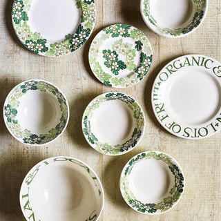 Green, white and grey floral patterned plates laid out on table