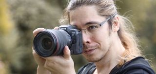 Photographer James Artaius holding a Canon EOS R5 up to his eye