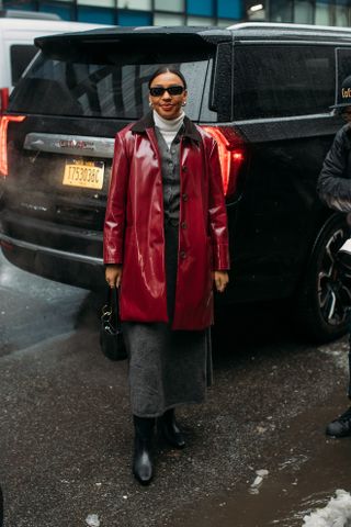 woman wearing red trench coat, gray blazer, gray skirt