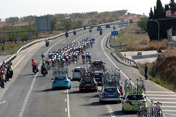 A Pro Tour caravan Takes up the whole road and requires more support personnel than the number of racers