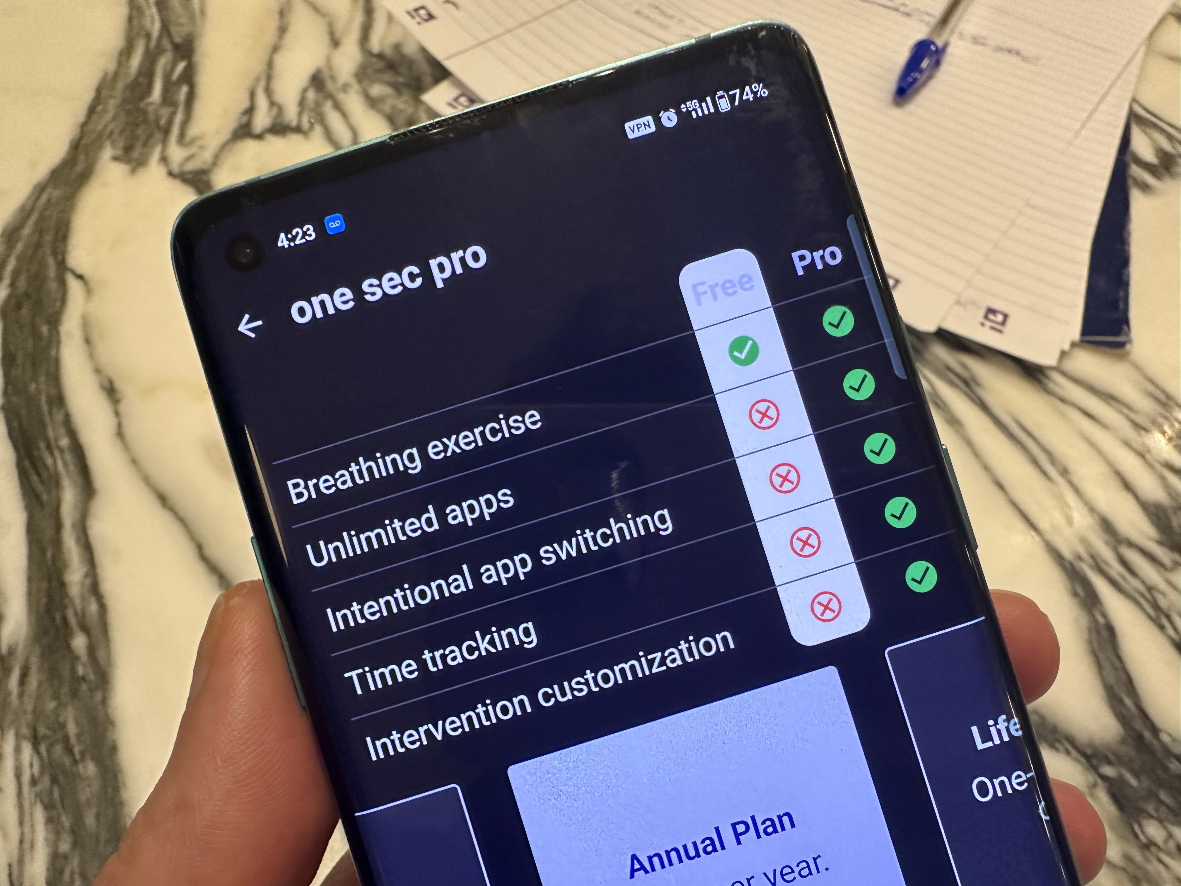 Aplicación One Sec, abierta en un teléfono inteligente Android contra una mesa de mármol.