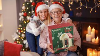 People wearing Santa hats, holding a Vinguys Smart Feeder in a Christmas setting