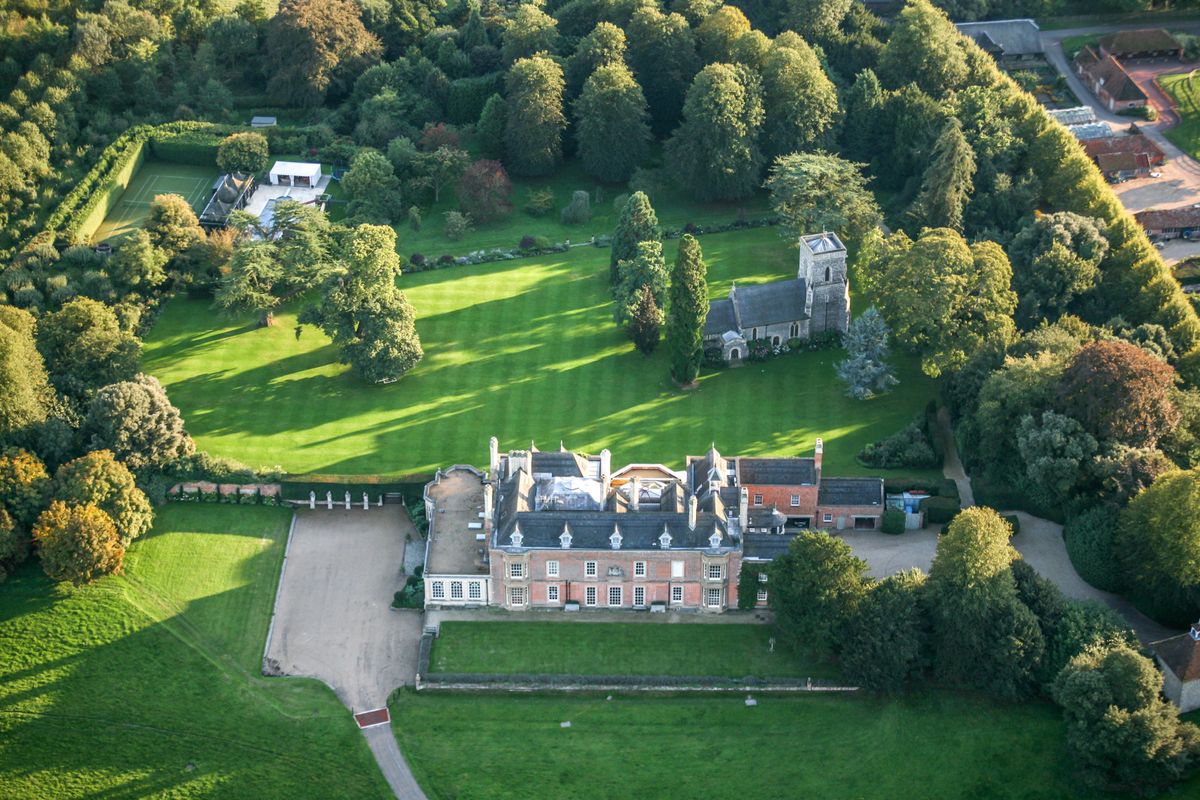 Aerial photograph of Sydmonton Court in Hampshire shows a large front and back garden, tennis court, and large outbuilding around a large mansion