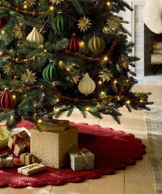 Christmas tree with red skirt and red, white and green decorations