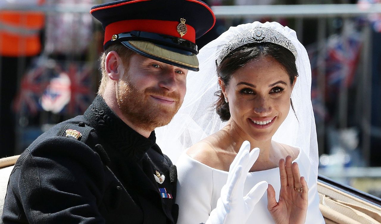 Prince Harry and Meghan Markle wave from the Ascot Landau Carriage during their carriage procession on the Long Walk as they head back towards Windsor Castle in Windsor, on May 19, 2018 after their wedding ceremony. 