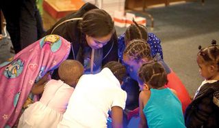 HackSchool student founder, Shukri Hassan, facilitates a robotics workshop with middle- and elementary-school students at the Village Exchange Center in Aurora, CO.