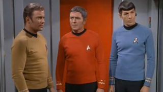 William Shatner stands looking worried with James Doohan and Leonard Nimoy watching on in the Star Trek series finale.