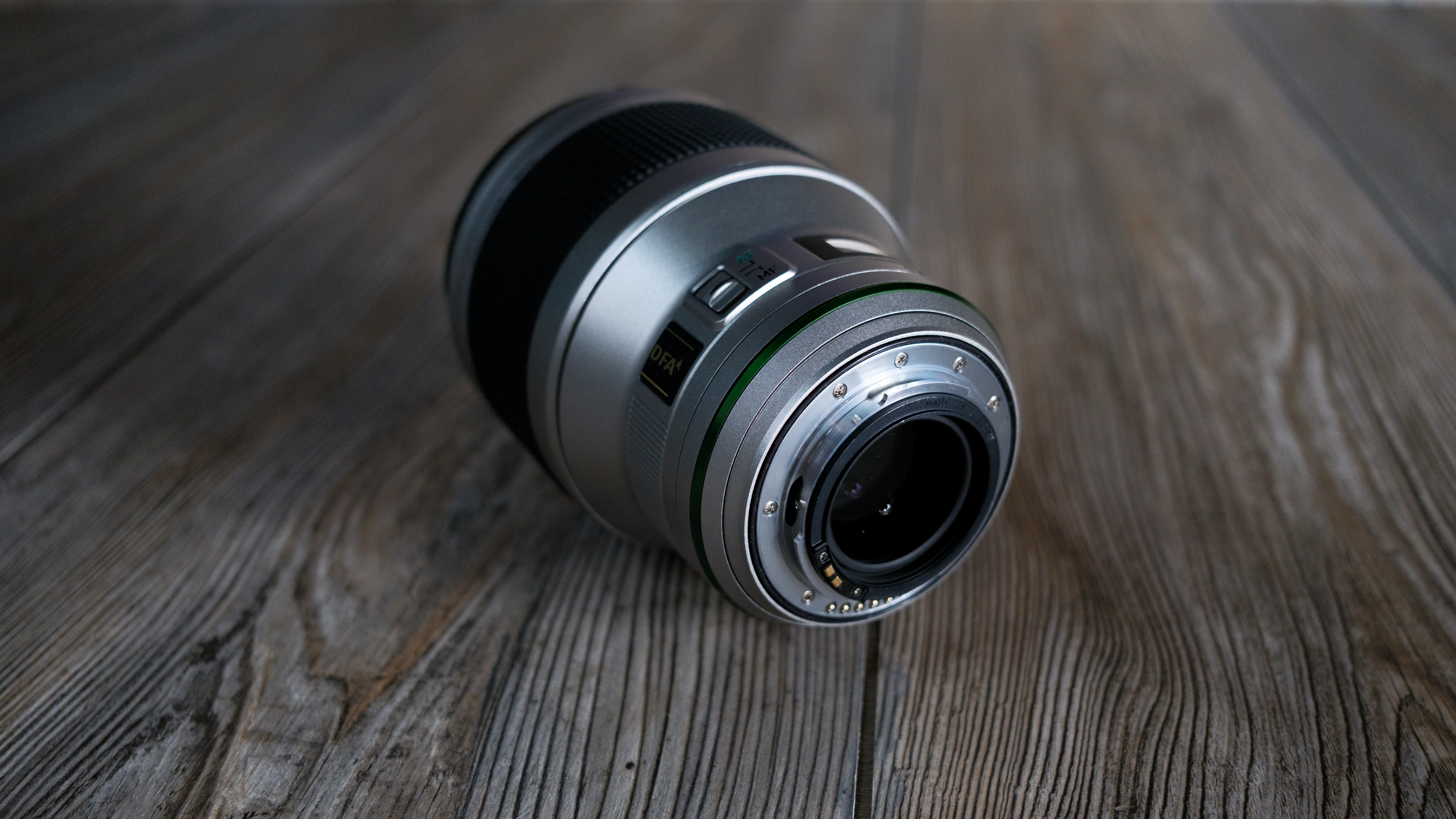 The Pentax 85mm f/1.4 SDM AW on a wood background