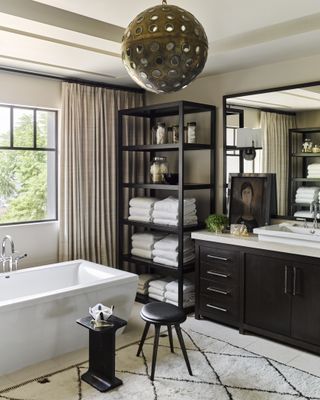 bathroom in a home spa look with dark furniture and shelving