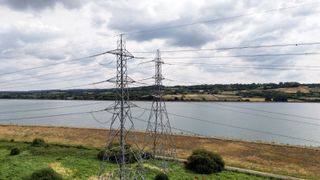 Aerial view of electricity pylons and reservoir