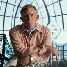 Daniel Craig as Benoit Blanc, standing in a glass atrium, in 'Glass Onion: A Knives Out Mystery'