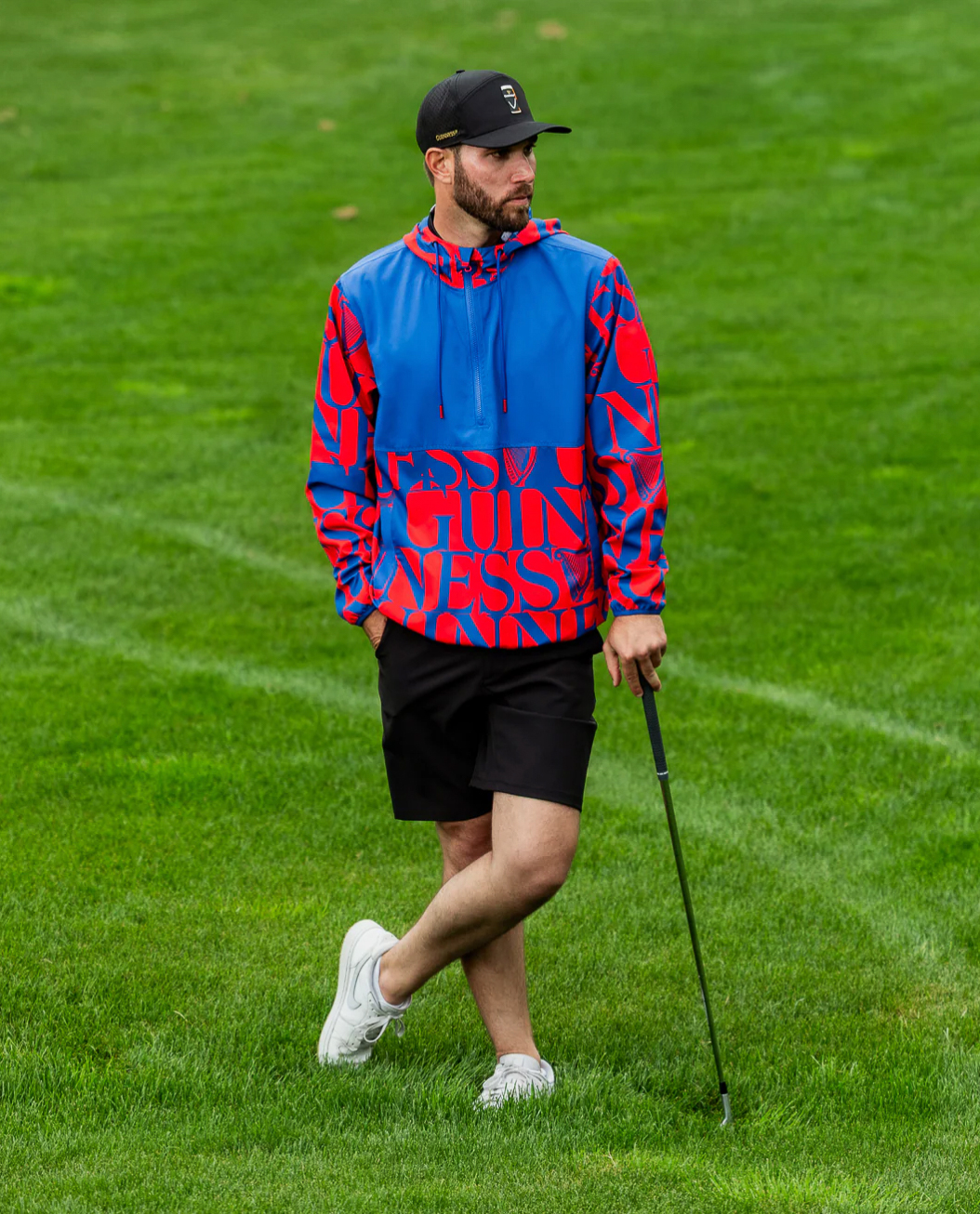 Male golfer wearing Sunday Swagger Another Round Guinness Men's Q-Zip Jacket