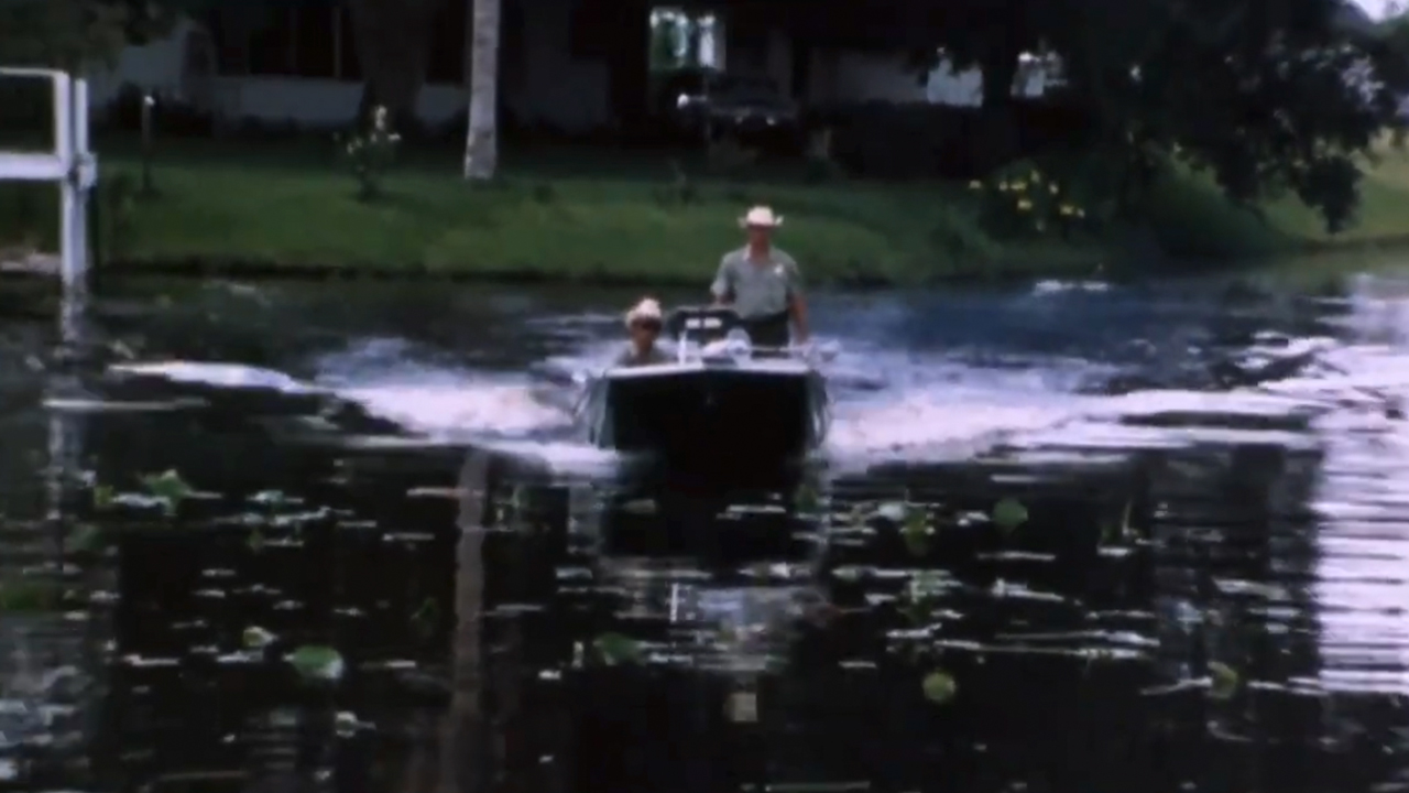 Two police officers in a power boat on a lake in Faces of Death