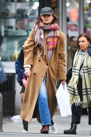 Katie Holmes in a camel coat, blue jeans, and plaid scarf.