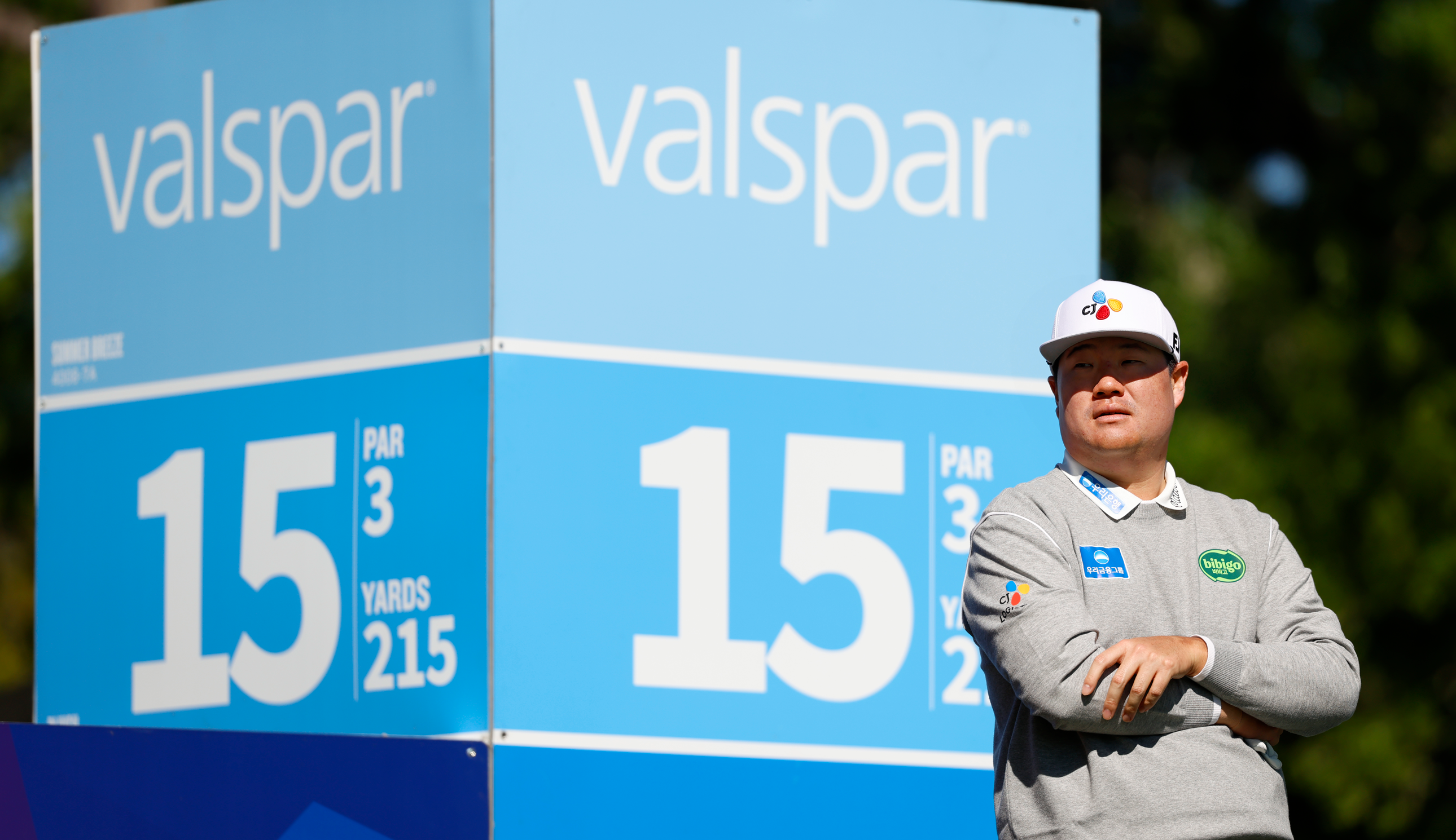 Sungjae Im stands in front of a Valspar Championship marker