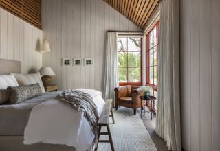 Panelled bedroom with high ceilings and red windows