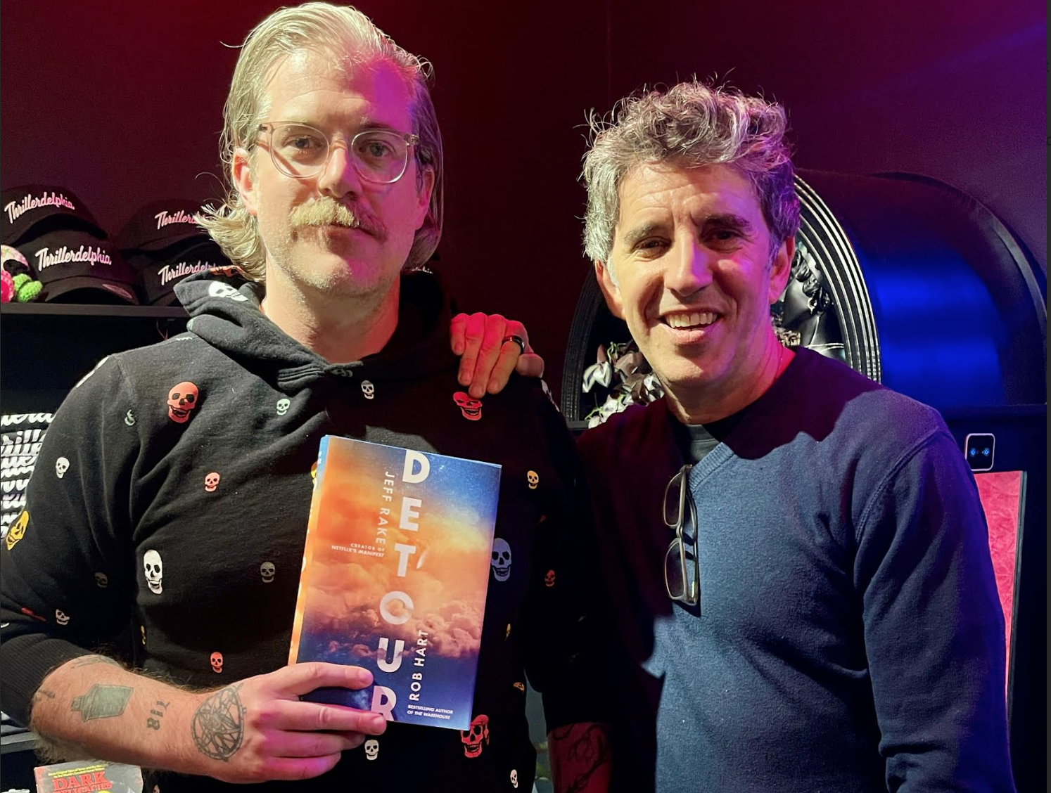 Two men on a book tour holding their novel