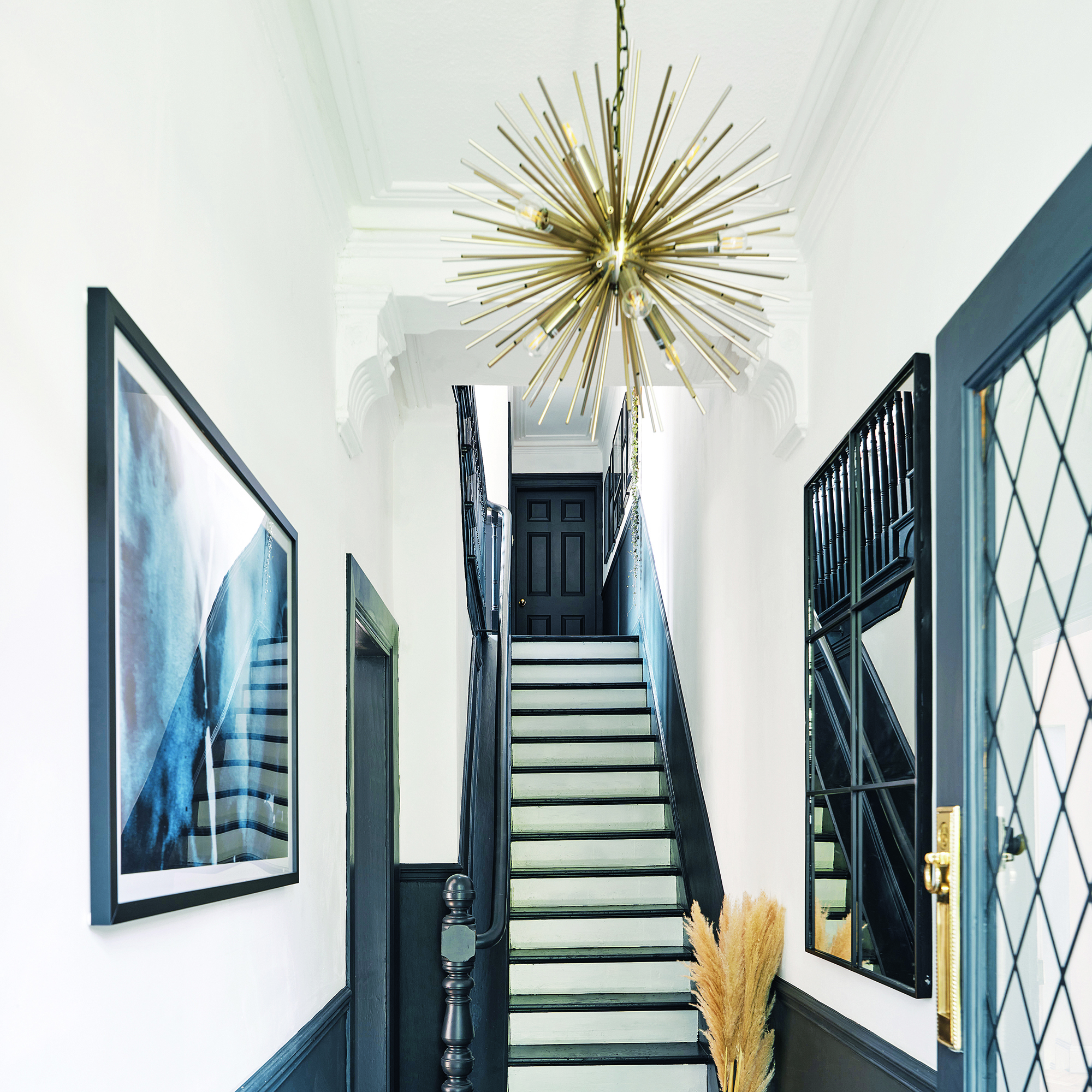 Hallway with navy accents and large pendant light.