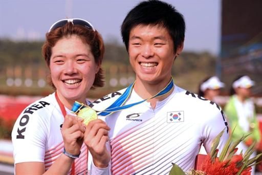 Korea's Min Hye Lee, left, and Hyeongmin Choe celebrate their gold medals in the women's and men's time trial at the Asian Games.