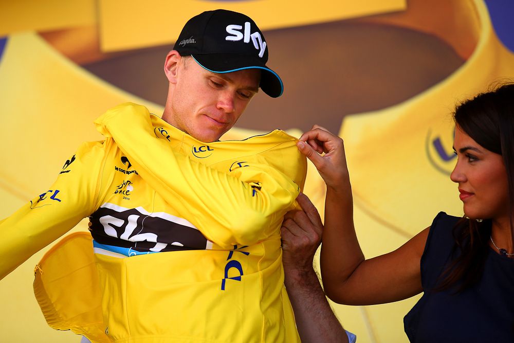 Chris Froome pulls on the yellow jersey following stage 11.