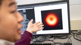 Kazunori Akiyama, a coordinator of the EHT Imaging Working Group, is pictured with the image during the process of checking the data.