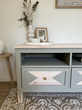A customised IKEA HEMNES TV unit painted pale green with a geometric pattern