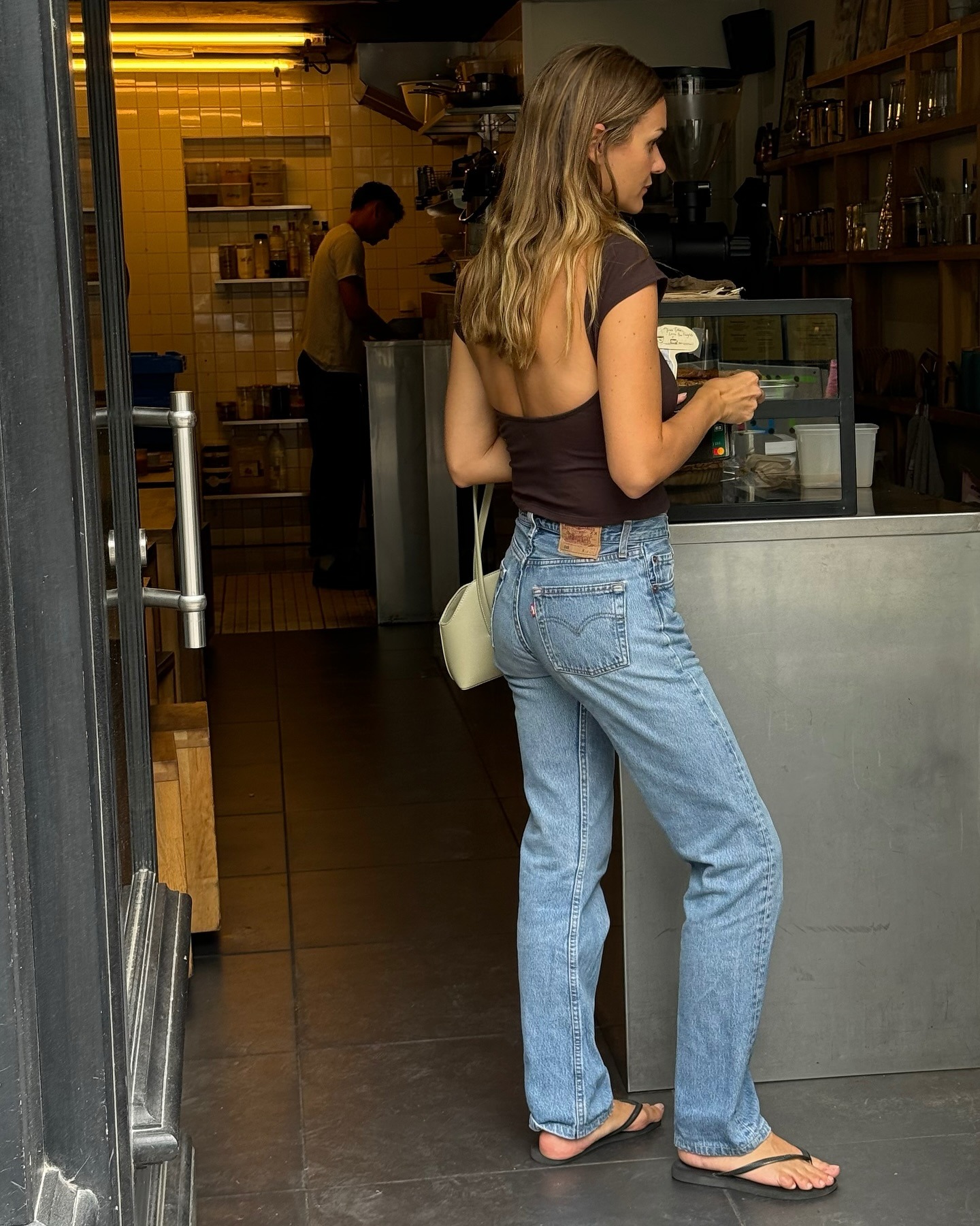 @annelauremais wearing high-waisted Levi's jeans with flip-flops.