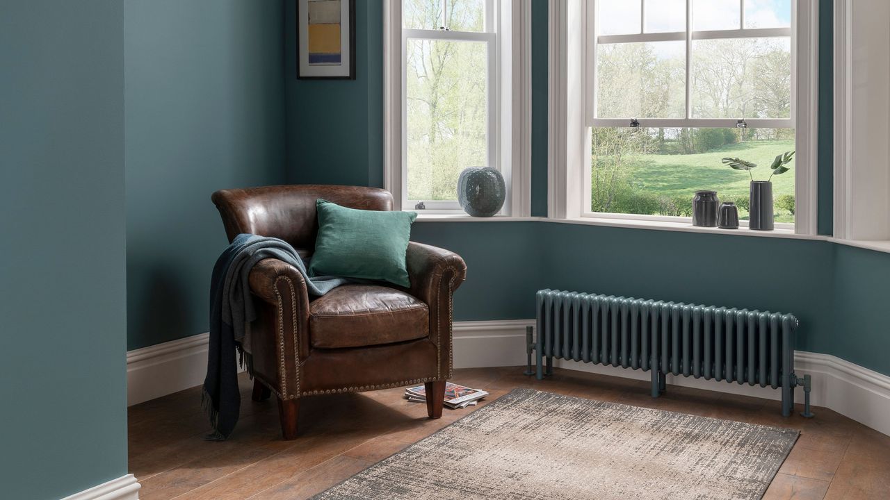 large radiator in living space with window and armchair